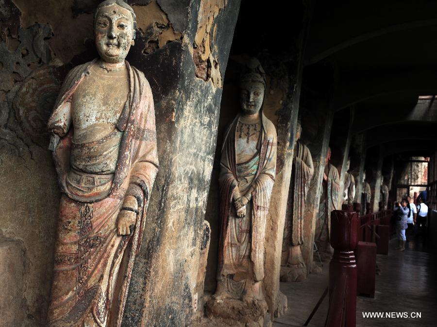 Photo taken on July 15, 2013 shows sculptures at the Maiji Mountain Grottoes in Tianshui, northwest China's Gansu Province. After protection and preparation, the Maiji Mountain Grottoes, the fourth largest grottoes in China and known as the "Oriental Sculpture Museum", has been ready for the application for status on the World Heritage List in 2014, as a part of the application program of the 2,000-year-old Silk Road which China works with Kazakstan and Kyrgyzstan and was officially submitted to the United Nations Educational, Scientific and Cultural Organization (UNESCO) in January of 2013. China has altogether 22 historical sites in this application program, including seven in Xinjiang, five in Gansu, six in Shaanxi and four in Henan. (Xinhua/Nie Jianjiang) 