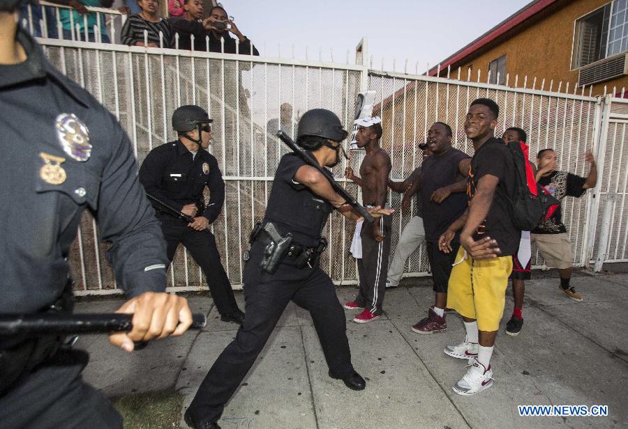 Protesters confront police officers during a demonstration to protest George Zimmerman's acquittal in the shooting death of Florida teen Trayvon Martin, in Los Angeles, California, July, 15, 2013.A Jury in U.S. state Florida on July 13 acquitted George Zimmerman, who shot and killed Seventeen-year-old African American teenager Trayvon Martin on Feb. 26, 2012, in a case which sparked heated debate on race and guns. (Xinhua/Zhao Hanrong)
