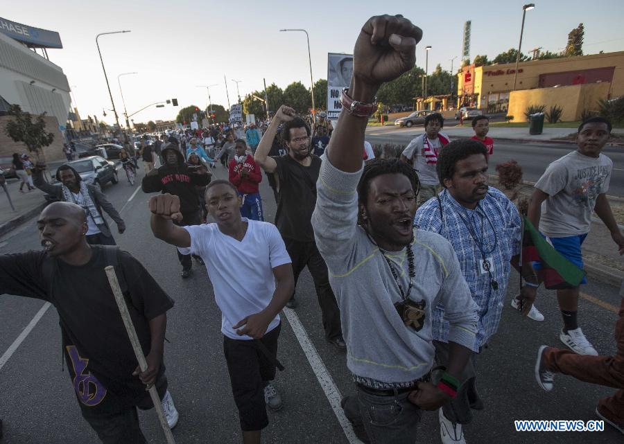 Protesters confront police officers during a demonstration to protest George Zimmerman's acquittal in the shooting death of Florida teen Trayvon Martin, in Los Angeles, California, July, 15, 2013.A Jury in U.S. state Florida on July 13 acquitted George Zimmerman, who shot and killed Seventeen-year-old African American teenager Trayvon Martin on Feb. 26, 2012, in a case which sparked heated debate on race and guns. (Xinhua/Zhao Hanrong)