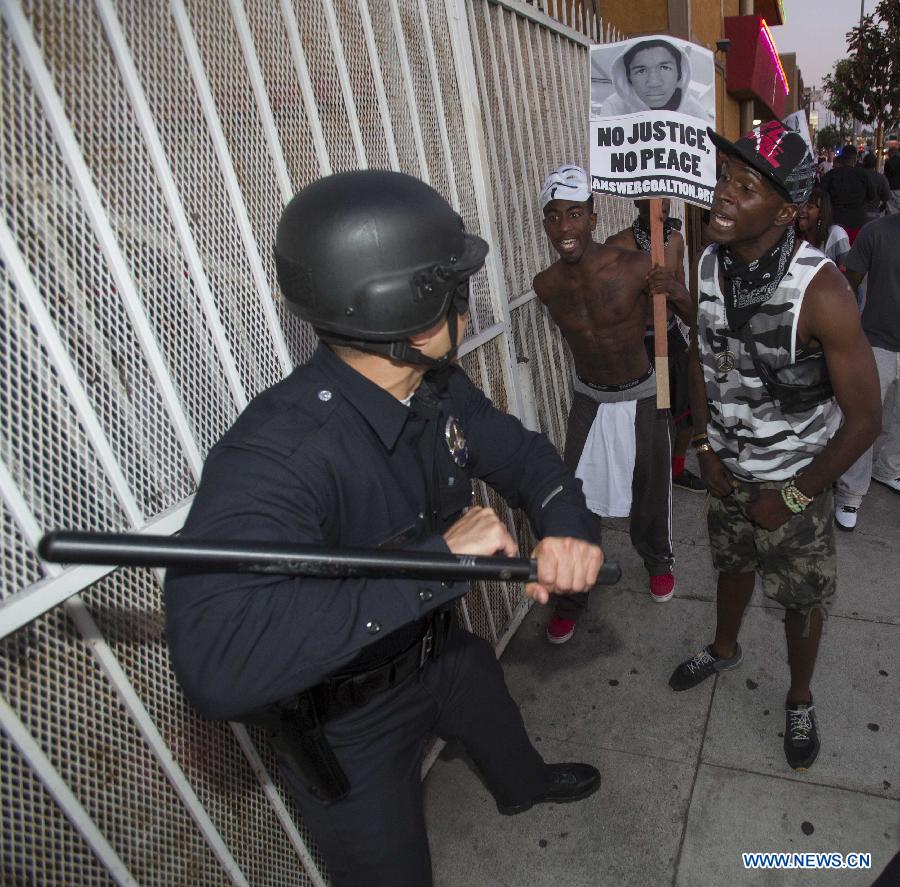 Protesters confront police officers during a demonstration to protest George Zimmerman's acquittal in the shooting death of Florida teen Trayvon Martin, in Los Angeles, California, July, 15, 2013.A Jury in U.S. state Florida on July 13 acquitted George Zimmerman, who shot and killed Seventeen-year-old African American teenager Trayvon Martin on Feb. 26, 2012, in a case which sparked heated debate on race and guns. (Xinhua/Zhao Hanrong)