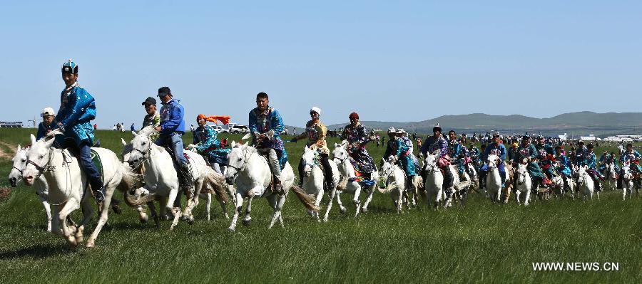 Herdsmen are seen in a horse race at the White Horse Festival in the West Ujimqin Banner of north China's Inner Mongolia Autonomous Region, July 16, 2013. With rodeos and races, the White Horse Festival will last two days .(Xinhua/Ren Junchuan) 