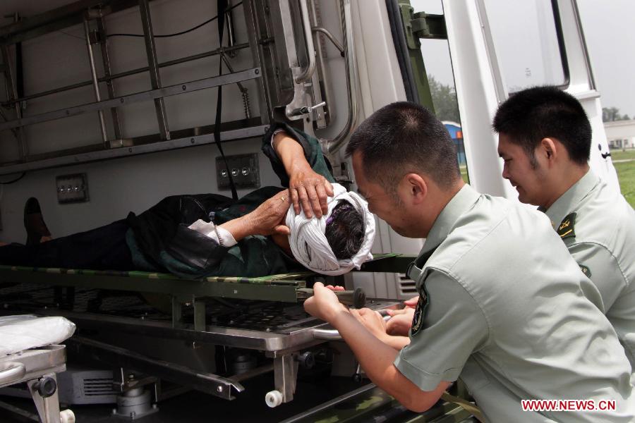 Relief workers transfer an injured person to a helicopter in Caopo Township of Wenchuan County, southwest China's Sichuan Province, July 16, 2013. The People's Liberation Army (PLA) Chengdu Military Area Command has dispatched helicopters to help with relief work in Wenchuan County which has been affected by flooding. An aviation unit dispatched three helicopters with 19 relief workers and 7.5 tonnes of materials in 12 flights to Caopo Township of Wenchuan County, which suffered downpours and mud-rock flows, according to the area command. (Xinhua/Wu Yongbin)