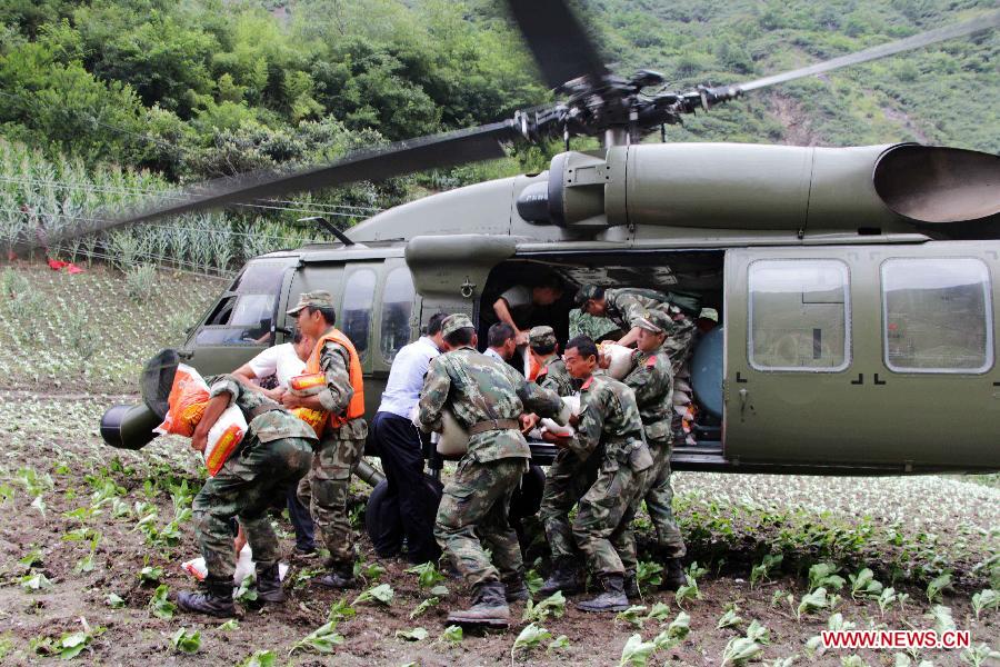 Relief workers unload disaster-relief supplies from a helicopter in Caopo Township of Wenchuan County, southwest China's Sichuan Province, July 16, 2013. The People's Liberation Army (PLA) Chengdu Military Area Command has dispatched helicopters to help with relief work in Wenchuan County which has been affected by flooding. An aviation unit dispatched three helicopters with 19 relief workers and 7.5 tonnes of materials in 12 flights to Caopo Township of Wenchuan County, which suffered downpours and mud-rock flows, according to the area command. (Xinhua/Wu Yongbin)