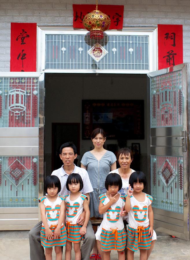 Quadruplet sisiters and  their grandparents and mother take family photo. (Xinhua/ Hu Chenhua) 