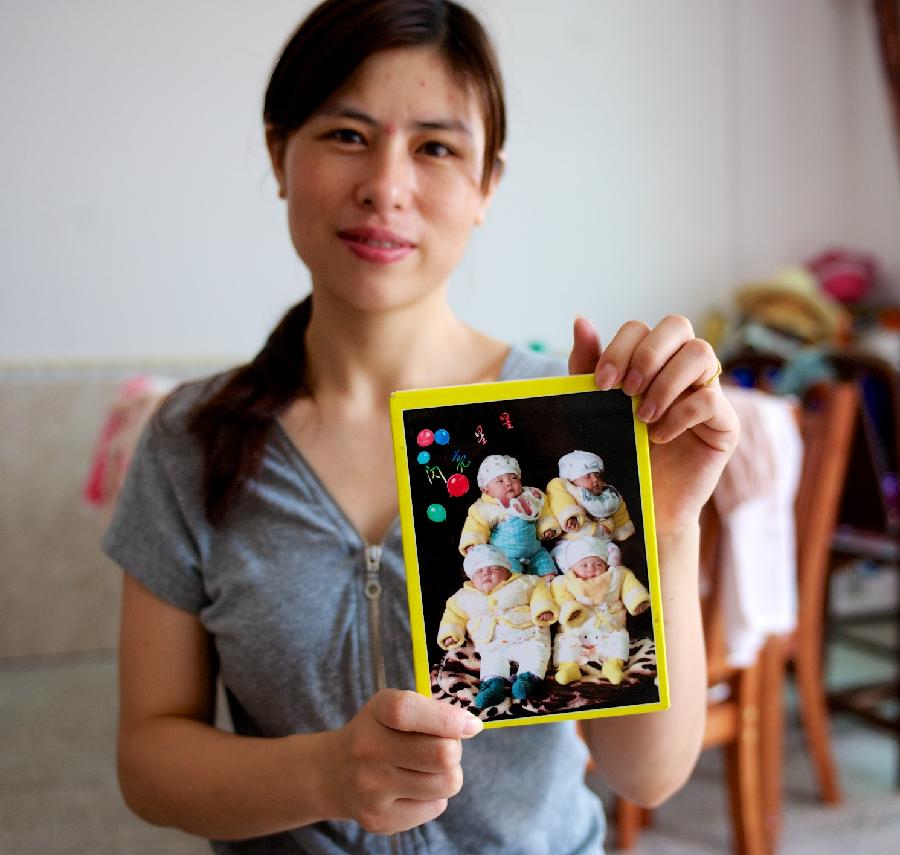 Zhu Yanhong shows old photo of four sisters. ( (Xinhua/Hu Chenhuan))