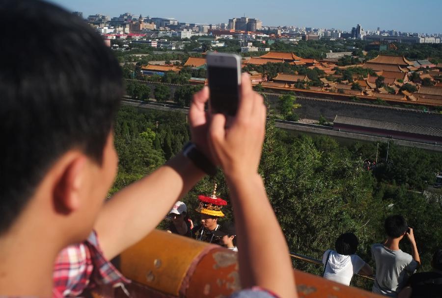 Tourists take photo of scenery of Jingshan Park in Beijing, capital of China, July 16, 2013. After a few days of rain and haze, Beijing witnesses sunshine and clear sky on July 16, 2013. (Xinhua/Wang Shen) 