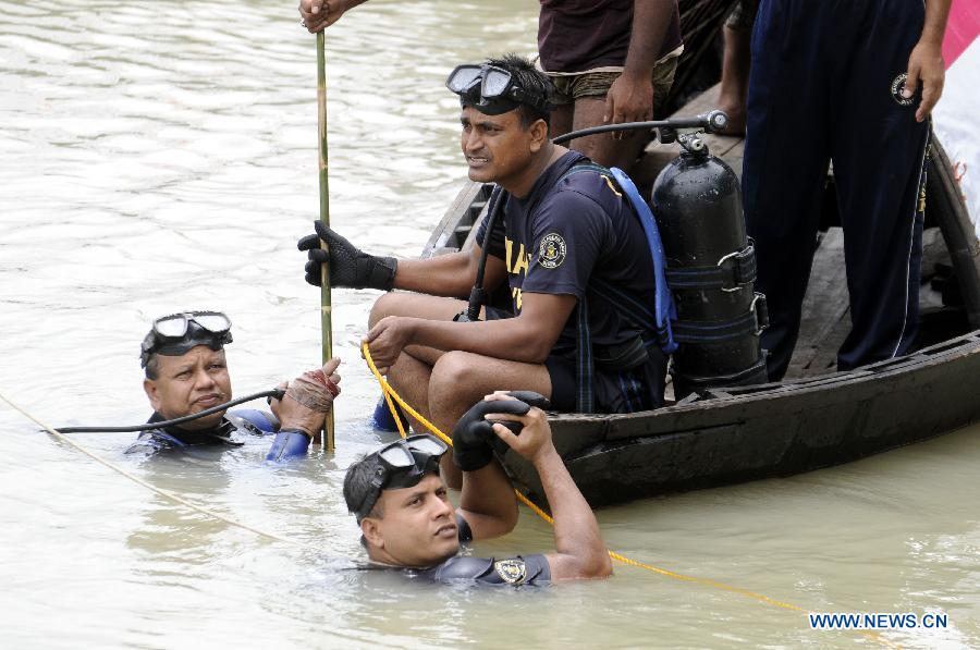 Rescuers search for victims in the Turag river after a road accident at Ashuria on the outskirts of Dhaka, capital of Bangladesh, July 16, 2013. A passenger bus fell in to a river on the outskirts of Bangladesh's capital Dhaka Tuesday morning, leaving 5 people dead and 19 others missing, fire service officials said. (Xinhua/Shariful Islam)
