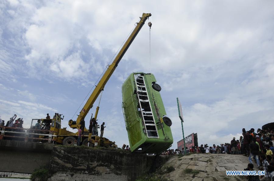 A bus that plunged into the river is pulled out from the river at Ashuria on the outskirts of Dhaka, capital of Bangladesh, July 16, 2013. A passenger bus fell in to a river on the outskirts of Bangladesh's capital Dhaka Tuesday morning, leaving 5 people dead and 19 others missing, fire service officials said. (Xinhua/Shariful Islam)