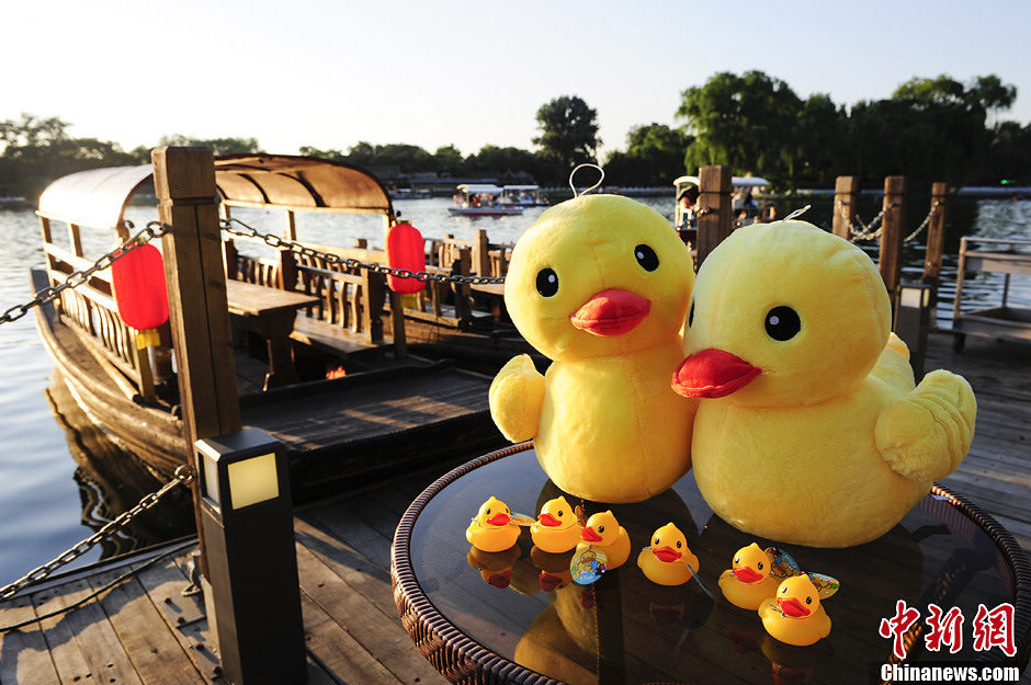 Little rubber ducks are “invited” to board the boats in Beijing's Shichahai Lake, July 16, 2013. The recent news saying that the Rubber Duck will visit Beijing this September has attracted Robber Duck fans’ attention. As one of the candidate places to host the Robber Duck, Shichahai Lake organized some events to welcome the Robber Duck. People who book group boat tickets online and take photos with little rubber ducks on the boat will get an authentic Rubber Duck doll. (Photo/Chinanews)