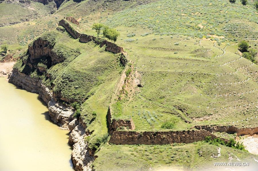 A section of Great Wall built in Ming dynasty (1368-1644) twists on cliff along the Yellow River in Laoniuwan geopark in Hohhot, north China's Inner Mongolia Autonomous Region, July 16, 2013. The Great Wall meets the Yellow River in Laoniuwan, which was turned into a geopark in December of 2012 and opened to the public on July 16, 2013.(Xinhua/Jin Yu) 