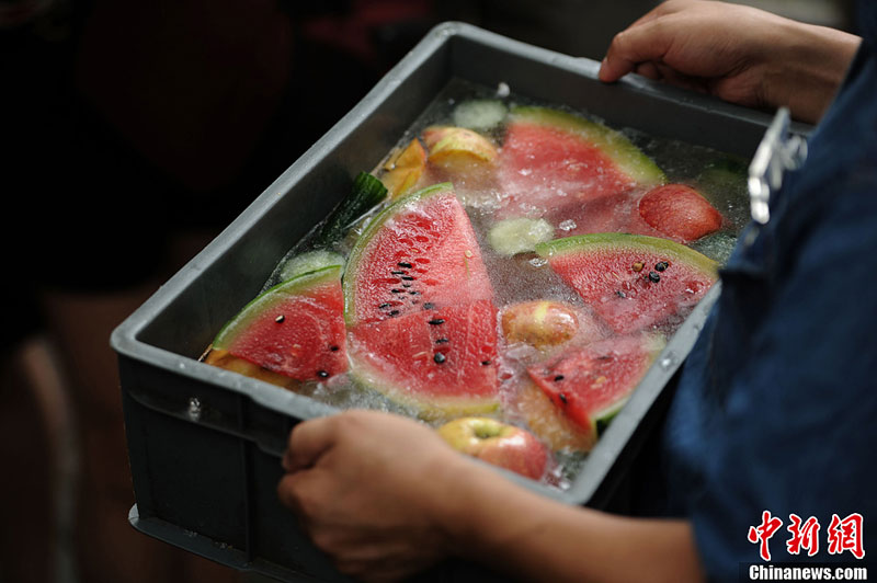 Brown bears in Chongqing's Yangjiaping Zoo enjoy iced watermelons to cool off. The downtown area of Chongqing suffers highest temperature since China's first climate records in 1951. It is 2.7 degrees Celsius higher than the same period in previous years. [Photo: Chinanews.com] 