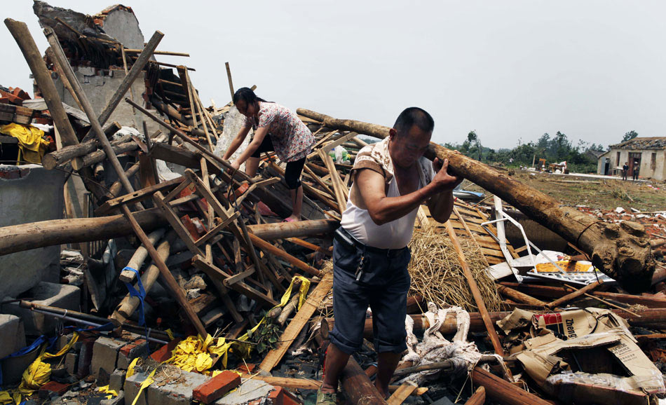 Villagers clean off their houses destroyed by a powerful tornado in east China’s Anhui province, July 8, 2013. In addition to flattening houses, the tornado cut the village’s power and left thousands of people in the dark. (Xinhua/Li Bingwang)