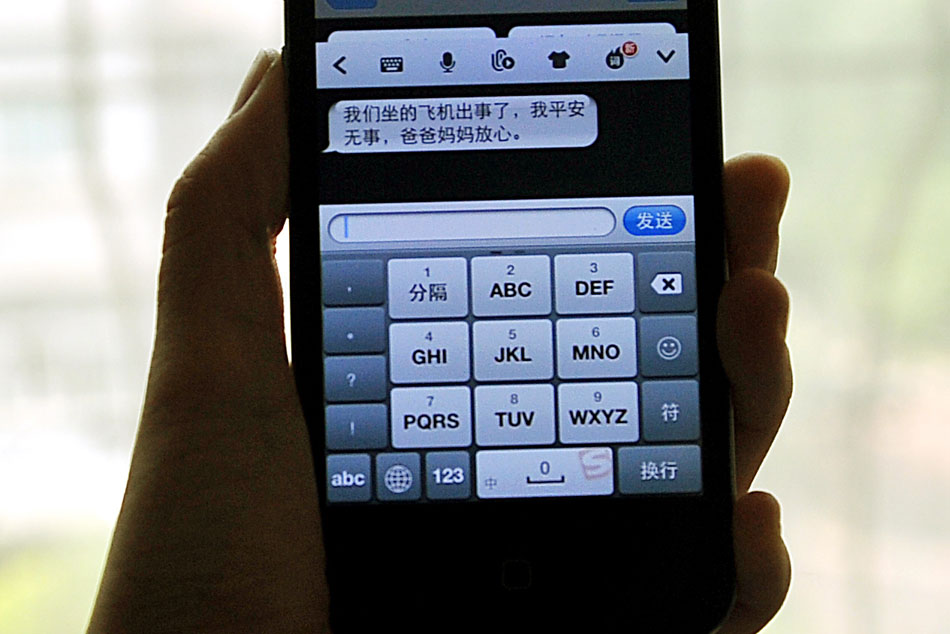 A Chinese reporter shows a mobile message sent from the parent of a student who boarded on Asiana Airlines flight 214 following the aircraft crashed in San Francisco and killed three Chinese students, July 7. The message was the content of the call between the student and the parent and read “Our plane met big trouble but I’m fine. Please don’t worry about me.”(Xinhua/Zhan Yan) 