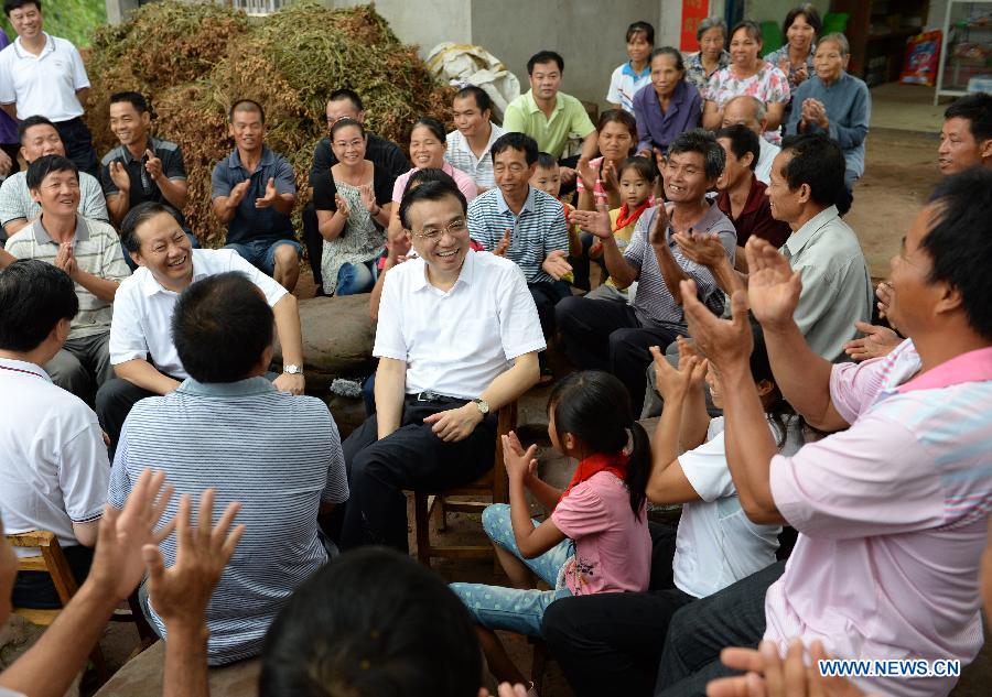 Chinese Premier Li Keqiang talks with local residents in Tanliang Village of Nanning City, capital of south China's Guangxi Zhuang Autonomous Region, July 9, 2013. China's top leadership has called on local officials to vigorously promote the "mass line" education campaign and apply it to boosting development and people's livelihoods. "Mass line" refers to a guideline under which the Communist Party of China officials and members are required to prioritize the interests of the people and persist in representing them and working on their behalf. (Xinhua/Ma Zhancheng)
