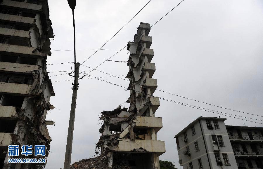 A piece of wall stands precariously after a demolition in Wuhan, Hubei province, July 14, 2013. The 10-storey building was under demolition and the middle part removed, leaving concrete slabs on both sides. The piece of wall, without any safety measures, is next to a 5-storey residence, triggering fear from nearby residents and passing pedestrians. (Photo/Xinhua) 