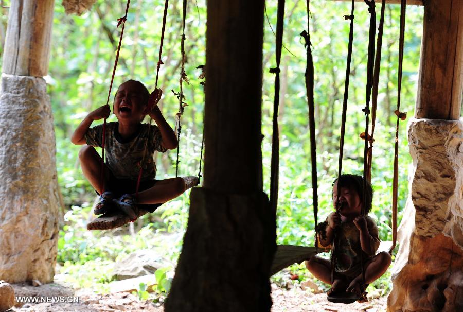 Children play on the swing in Nongyong Village of Dahua Yao Autonomous County in south China's Guangxi Zhuang Autonomous Region, July 14, 2013. (Xinhua/Huang Xiaobang)