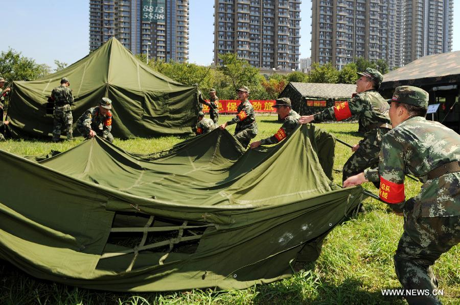 Soldiers put up a tent in a rescue drill held in Hangzhou of east China's Zhejiang Province, July 17, 2013. The emergency drill was held on Wednesday to improve the reaction capability against typhoon. (Xinhua/Ju Huangzong)