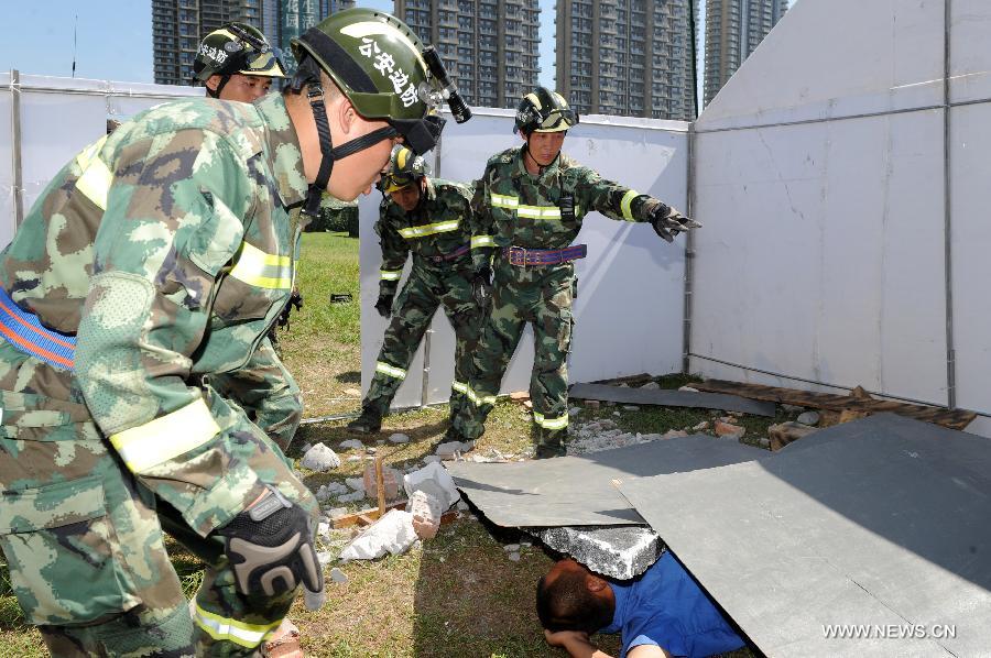 Soldiers search for the trapped people in a rescue drill held in Hangzhou of east China's Zhejiang Province, July 17, 2013. The emergency drill was held on Wednesday to improve the reaction capability against typhoon. (Xinhua/Ju Huangzong)