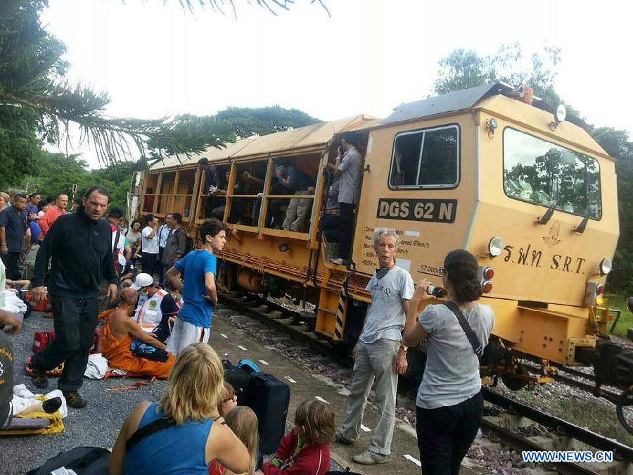 Passengers gather at the site where a train derailed near Den Chai district of northern Phrae province, Thailand, on July 17, 2013. 30 people were injured when a train from the capital to northern Thailand derailed on Wednesday early morning. (Xinhua)