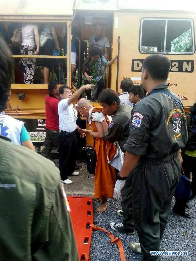 Rescuers work at the site where a train derailed near Den Chai district of northern Phrae province, Thailand, on July 17, 2013. 30 people were injured when a train from the capital to northern Thailand derailed on Wednesday early morning. (Xinhua)