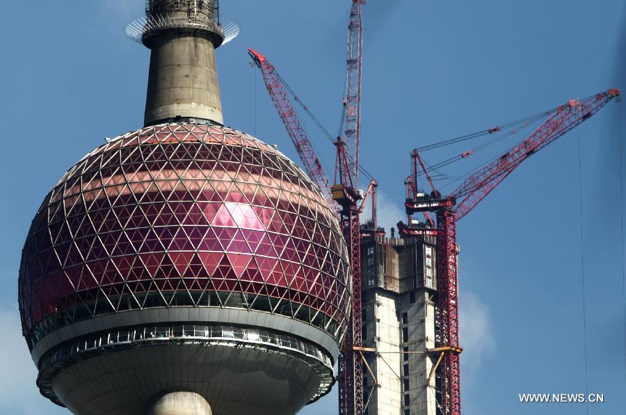 Photo taken on July 17, 2013 shows Shanghai Tower under construction and the Oriental Pearl Tower in east China's Shanghai. Shanghai Tower is soon to seal its roof and will redefine the Lujiazui area skyline.(Xinhua/Pei Xin)