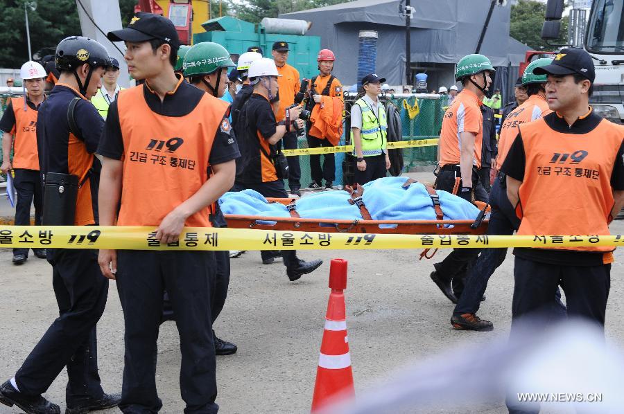 Rescuers move the victim's body in Seoul, capital of South Korea, on July 17, 2013. Rescue workers on Wednesday retrieved the body of one of the six workers who went missing at a flooded underground waterworks construction site in Seoul two days ago, according to Yonhap News Agency. The body was identified as a Chinese worker. (Xinhua)