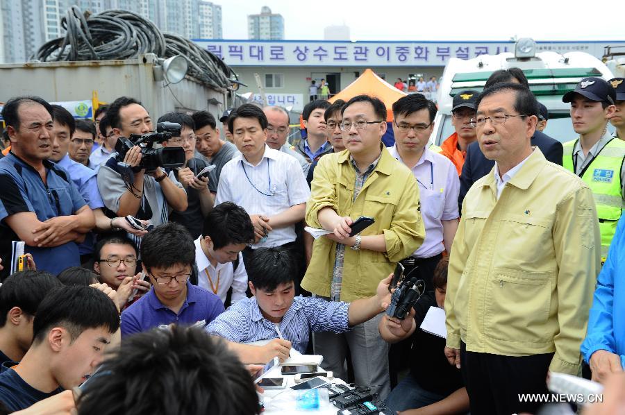 Seoul Mayor Park Won-soon (1st R, Front) speaks to the media in Seoul, capital of South Korea, on July 17, 2013. Rescue workers on Wednesday retrieved the body of one of the six workers who went missing at a flooded underground waterworks construction site in Seoul two days ago, according to Yonhap News Agency. The body was identified as a Chinese worker. (Xinhua)
