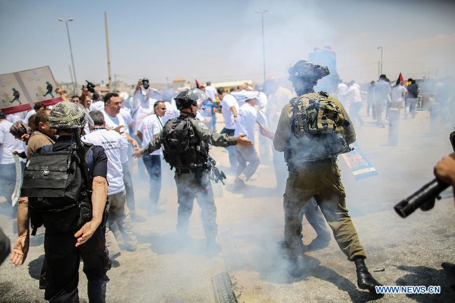 Israeli soldiers attacked dozens of Palestinian journalists as they attempted to cross to Jerusalem from Qalandiya checkpoint on July 17, 2013. Palestinian journalists launched a campaign of their freedom of Movement as they are banned from covering with Special Movement Permission from Israel. (Xinhua/Fadi Arouri)