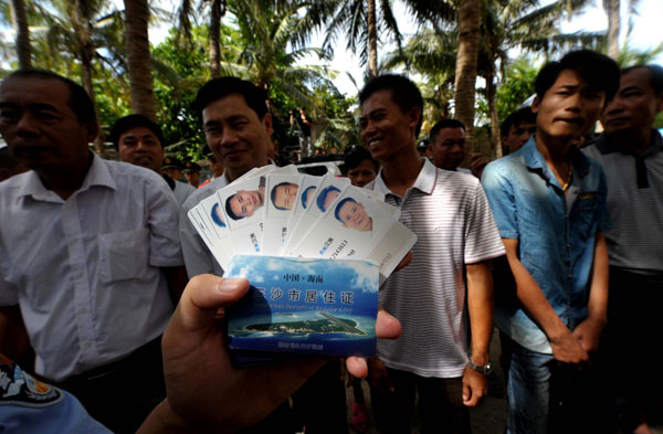 Residence permit cards are issued to residents in Sansha city, South China's Hainan province, July 17, 2013. The first batch of 10 identification cards and 68 residence permit cards are being issued to Sansha residents one year after its establishment. As China's youngest city, Sansha was officially set up last July on Yongxing Island in the South China Sea. The city administers three island groups - Xisha, Zhongsha and Nansha - and the surrounding waters in the South China Sea. (Photo/Xinhua)