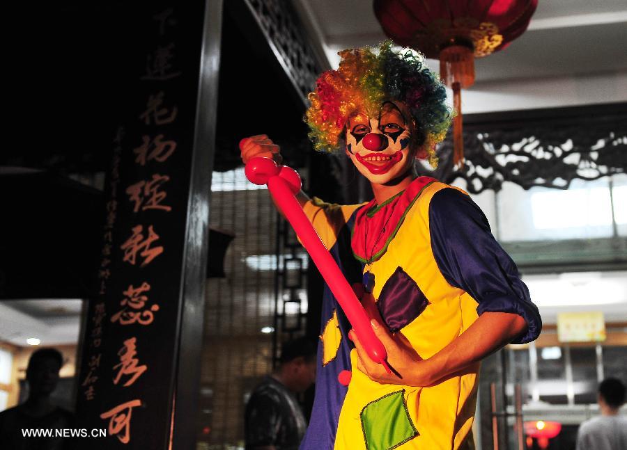 A clown performs at the Slender West Lake in Yangzhou, east China's Jiangsu Province, July 17, 2013. The night tour for visiting the Slender West Lake opened here on Wednesday. (Xinhua/Liu Jiangrui) 