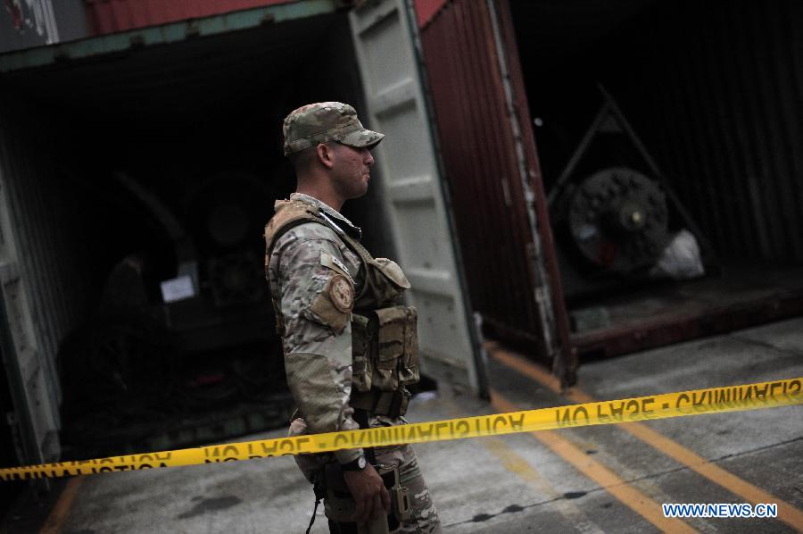 A police officer guards during the inspection of a container with military equipments aboard the "Chong Chon Gang" vessel from the Democratic People's Republic of Korea (DPRK), at the Manzanillo International container terminal on the coast of Colon City, Panama, July 17, 2013. The Democratic People's Republic of Korea (DPRK) on Thursday demanded the release of a vessel seized in Panama suspected of carrying narcotic drugs and banned arms, claiming the weapons were being transported under a legitimate contract with Cuba, the official KCNA news agency reported. (Xinhua/Mauricio Valenzuela)
