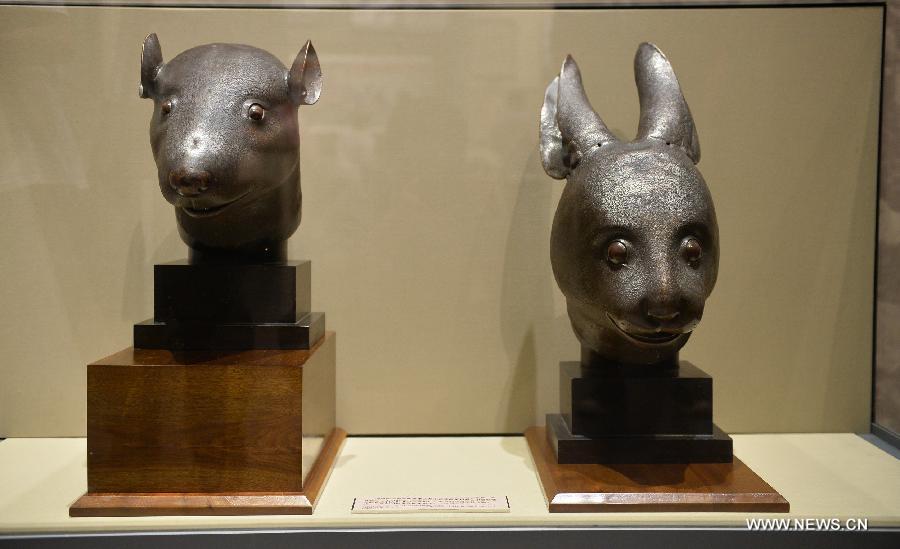 The bronze heads of a rat and a rabbit, donated by the Pinault family of France in April, are on display at the National Museum of China in Beijing, capital of China, July 18, 2013. The two pieces of relics were among 12 animal head sculptures that formed a zodiac water clock previously stood at Yuanmingyuan, or the Old Summer Palace, in northwest Beijing. They were looted by Anglo-French Allied forces during the Second Opium War in 1860. (Xinhua/Li Xin)