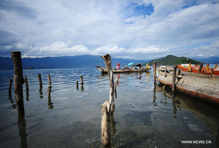 Tourists visit the Lugu Lake in the Yi Autonomous County of Ninglang, southwest China's Yunnan Province, July 17, 2013. Lugu is renowned for its beautiful scenery and the maintenance of the unique matriarchal system observed by the indigenous Mosuo people. (Xinhua/Qin Lang)