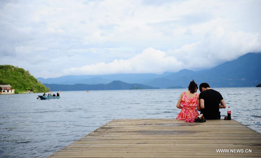 People enjoy themselves on the Lugu Lake in the Yi Autonomous County of Ninglang, southwest China's Yunnan Province, July 17, 2013. Lugu is renowned for its beautiful scenery and the maintenance of the unique matriarchal system observed by the indigenous Mosuo people. . (Xinhua/Qin Lang)