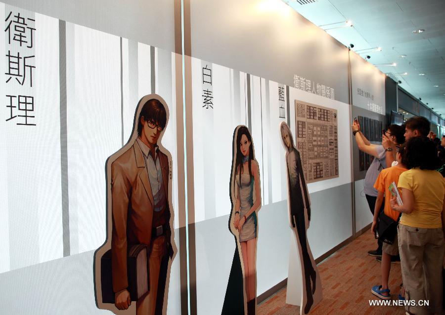 People visit an exhibition marking the 50th annivesary of the birth of Wesley, the main character in a series of science fictions written by novelist Ni Kuang, during the 24th Hong Kong Book Fair in south China's Hong Kong, July 18, 2013. The seven-day book fair, which kicked off Wednesday at Hong Kong Convention and Exhibition Center, attracted 560 exhibitors from 30 countries and regions. (Xinhua/Jin Yi)
