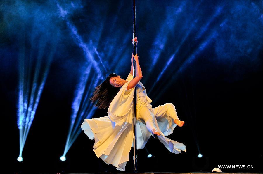 A dancer competes during the game of the 3rd China Pole Dance Championship in Tianjin, China, July 18, 2013. (Xinhua/Zhai Jianlan)
