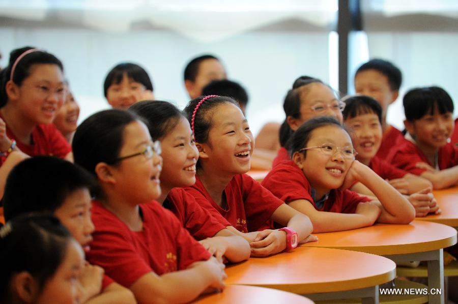 Children are seen at a lecture about Peking Opera given by Zhang Liehu, a national first-class performer, in a youth and children's development center in Hangzhou, east China's Zhejiang Province, July 18, 2013. The lecture is held to enrich children's life during summer vacation.(Xinhua/Ju Huanzong)  