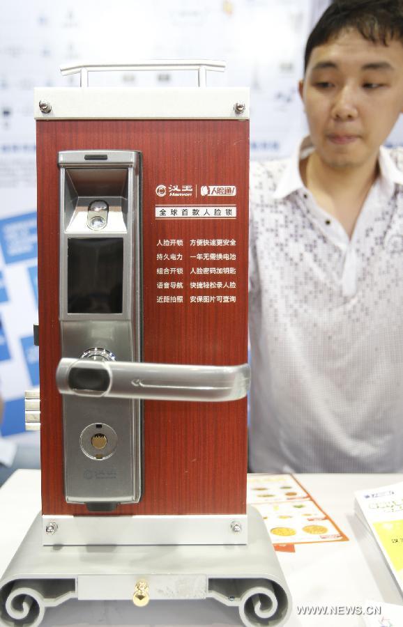 A visitor views face recognition lock at the 2013 China International Exhibition on Public Safety and Security in Beijing, capital of China, July 18, 2013. The exhibition kicked off on Thursday at China International Exhibition Center. (Xinhua/Zhao Bing)  