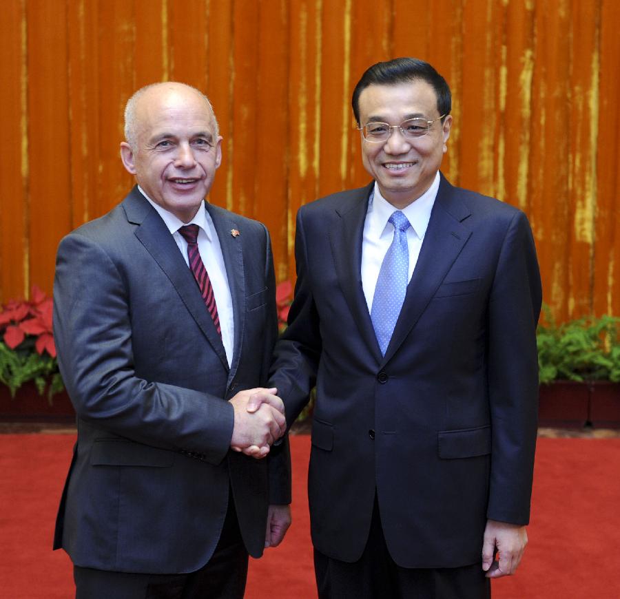 Chinese Premier Li Keqiang (R) shakes hands with Swiss President Ueli Maurer during their meeting in Beijing, capital of China, July 18, 2013. (Xinhua/Zhang Duo)