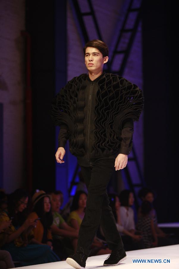 A model presents a creation during a fashion event showcasing works by graduates of the ESMOD (L'Ecole Superieure des Arts et Techniques de la Mode) Beijing, an international fashion institute, in Beijing, China, July 18, 2013. (Xinhua/Hou Dongtao) 