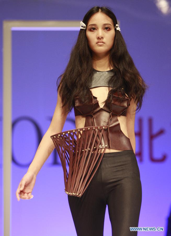 A model presents a creation during a fashion event showcasing works by graduates of the ESMOD (L'Ecole Superieure des Arts et Techniques de la Mode) Beijing, an international fashion institute, in Beijing, China, July 18, 2013. (Xinhua/Hou Dongtao) 