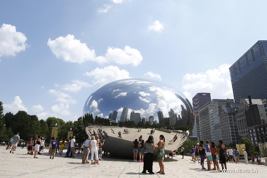 Tourists visit the Could Gate Sculpture in Millennium Park, with the heat index soaring pass 100 degrees Fahrenheit, in Chicago, the United States, July 18, 2013. (Xinhua/Ting Shen)