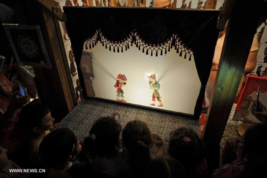 Children enjoy a shadow play in Istanbul on July 18, 2013. The shadow play has been played in Turkey for some 700 years and it has long been a tranditional entertainment in Ramadan. (Xinhua/Lu Zhe) 