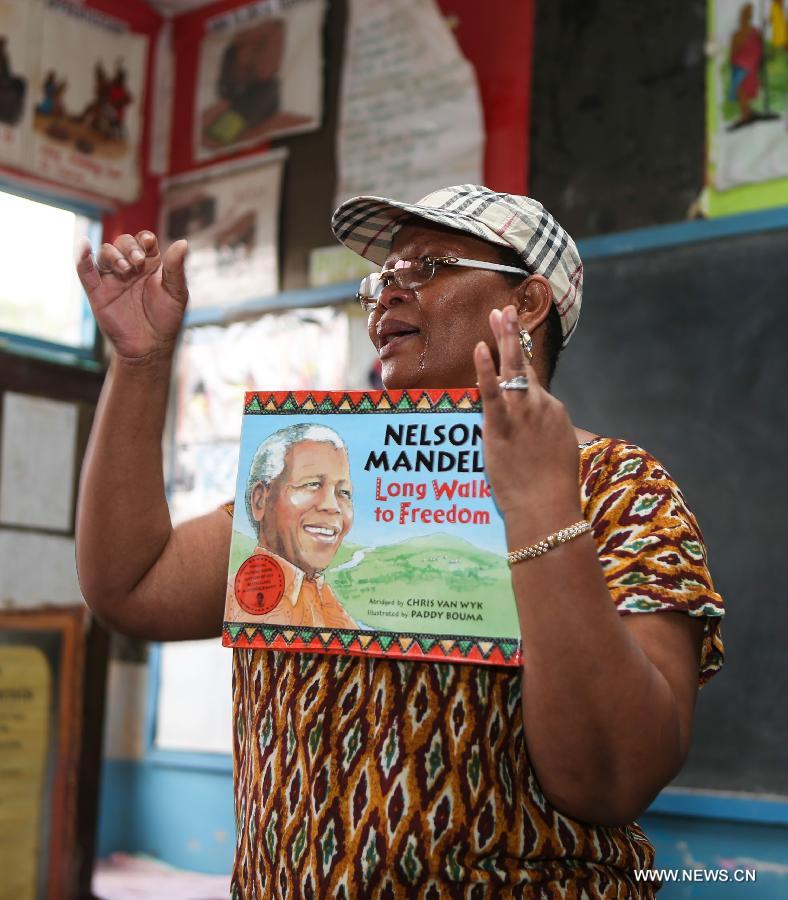 South Africa High Commission staff Helen Mashele tells stories on Mandela's long walk to freedom to students at Kilimani Primary School in Nairobi, capital of Kenya, July 18, 2013. A variety of activities, including tree planting, library wall painting and storytelling on Mandela's long walk to freedom, were held here on Thursday to celebrate Nelson Mandela Day. The theme for this year is "Take Action, Inspire Change and Make Every Day a Mandela Day." (Xinhua/Meng Chenguang) 