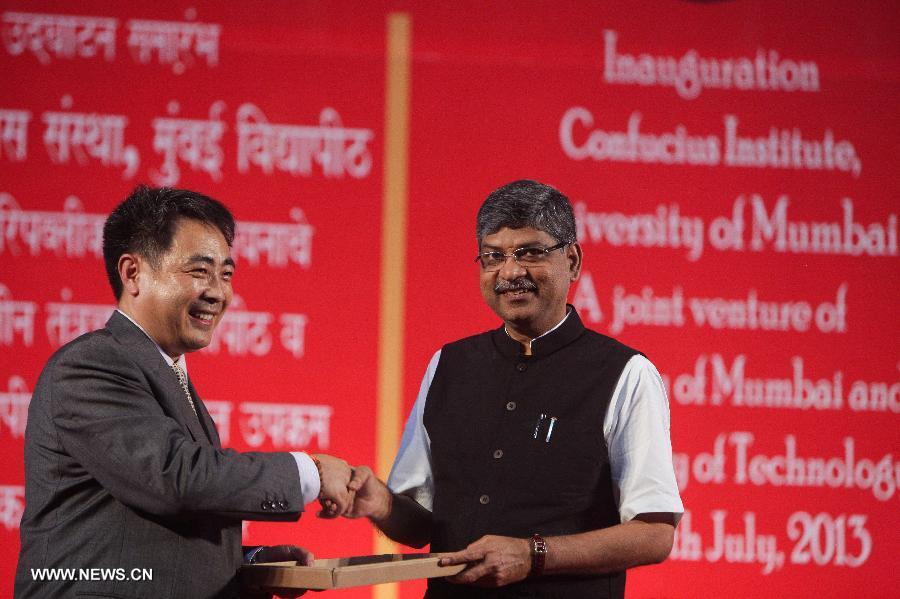 Meng Qingsong (L), Chairman of the Board of Tianjin University of Technology, gives a present to Dr. Rajan Welukar, Vice Chancellor of University of Mumbai, at the inauguration of the Confucius Institution at University of Mumbai in Mumbai, India, July 18, 2013. India's first confucius institute, jointly built by the University of Mumbai and China's Tianjin University of Technology, was inaugurated in Mumbai on Thursday. (Xinhua/Zheng Huansong)