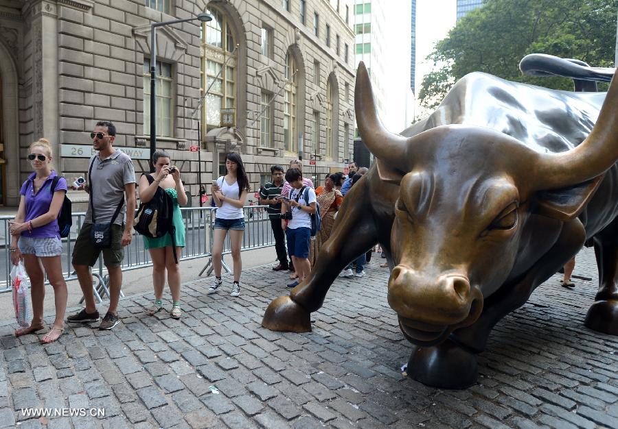 People queue beside the bronze bull in the Financial district which has become a Wall Street icon in New York City, July 18, 2013. U.S. stocks continued to rise on Thursday, sending the Dow Jones Industrial Average and the S&P 500 to fresh all-time highs, boosted by upbeat economic data and corporate earnings. (Xinhua/Wang Lei) 