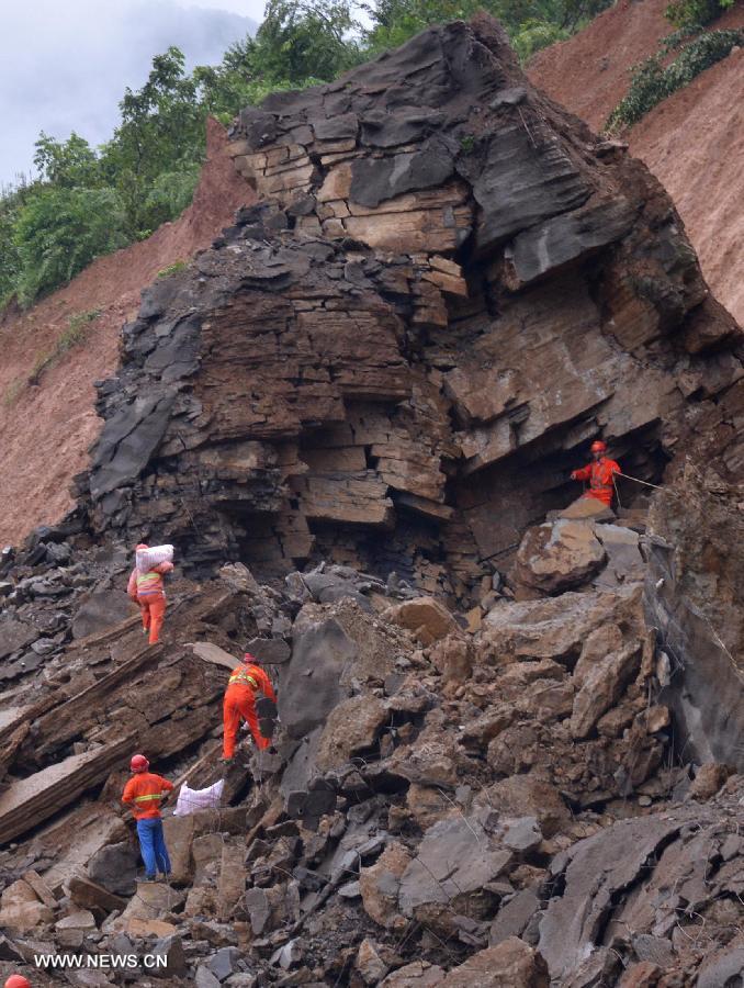 Workers place explosives at a blasting site above a barrier lake in Sanjiao Township of Hanyuan County, southwest China's Sichuan Province. The blasting is conducted to remove dangerous rocks and then dig channels to discharge the floodwater of the barrier lake. The lake was formed after a landslide and continuous rainfall, threatening residents downstream in Sichuan. (Xinhua/Xue Yubin) 