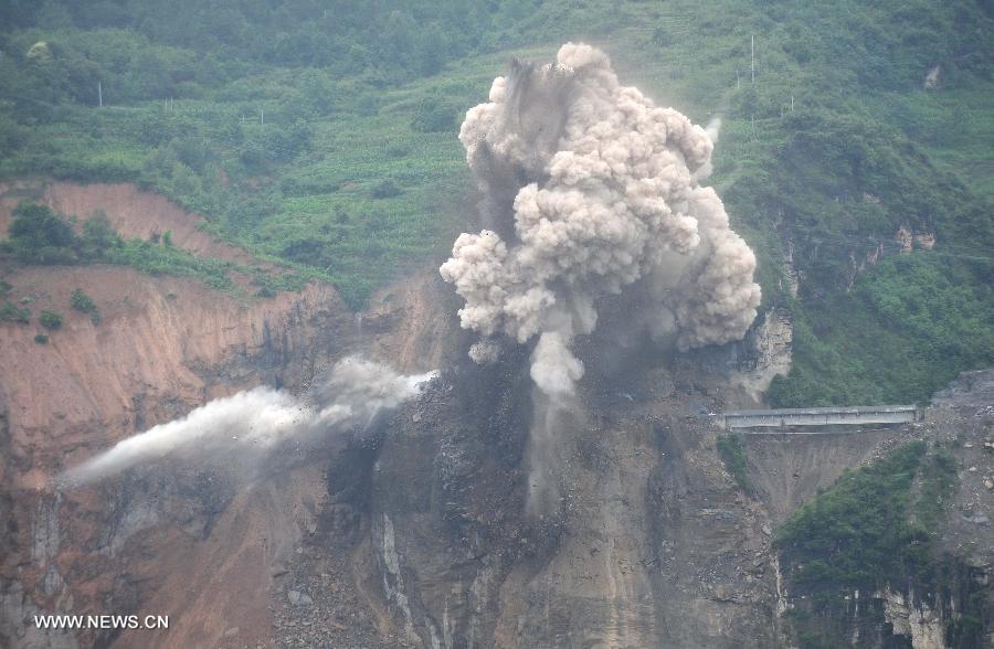 Photo taken on July 18, 2013 shows the blasting site above a barrier lake in Sanjiao Township of Hanyuan County, southwest China's Sichuan Province. The blasting is conducted to remove dangerous rocks and then dig channels to discharge the floodwater of the barrier lake. The lake was formed after a landslide and continuous rainfall, threatening residents downstream in Sichuan. (Xinhua/Xue Yubin) 