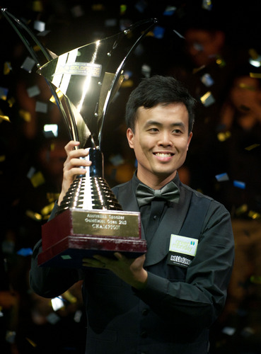 Marco Fu of China's Hong Kong presents the trophy after winning his final match against Neil Robertson of Australia at the 2013 Australian Goldfields Snooker Open in Bendigo, Australia, July 14, 2013. Marco Fu won 9-6 to claim the title. (Photo /Osports)