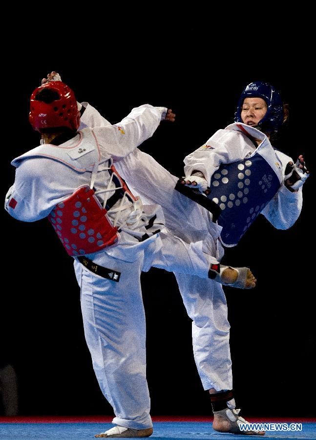 Mexico's Briseida Acosta (L) combats against Olga Ivanova (R) of Russia during the 73 kg women's category of the Taekwondo World Championship of the World Taekwondo Federation (WTF), at the Expositions and Coventions Center of Puebla, in Puebla, Mexico, on July 18, 2013. (Xinhua/Guillermo Arias)